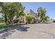 Charming multi-level condo with a beige stucco exterior, lush landscaping, and mature trees at 1446 E Grovers Ave # 13, Phoenix, AZ 85022