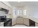 Bright kitchen features a black stove, double sink, and ample natural light at 1446 E Grovers Ave # 13, Phoenix, AZ 85022