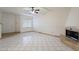 Spacious living room features a cozy fireplace, tile flooring, and bright natural light from a large window at 1446 E Grovers Ave # 13, Phoenix, AZ 85022