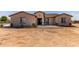Charming single-story home with tan stucco exterior and a low-pitched roof, front yard is not yet landscaped at 20310 W Hubbard Rd, Buckeye, AZ 85326