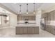 Bright, open kitchen with a large center island, stainless appliances, and stylish pendant lighting at 20310 W Hubbard Rd, Buckeye, AZ 85326