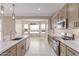 Open kitchen with stainless steel appliances, island sink, and tile flooring at 20310 W Hubbard Rd, Buckeye, AZ 85326