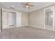 Carpeted main bedroom with ceiling fan, neutral walls, and multiple doors at 20310 W Hubbard Rd, Buckeye, AZ 85326