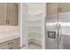 Walk-in pantry with built in shelves and lighting, stainless steel fridge at 20310 W Hubbard Rd, Buckeye, AZ 85326
