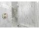 Elegant glass walk-in shower with seating, marble tiling and dual shower head at 20310 W Hubbard Rd, Buckeye, AZ 85326