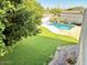 Expansive backyard with a well-kept lawn, pool with waterfall, and mature trees at 25015 N 50Th Ave, Phoenix, AZ 85083