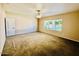 Spacious carpeted bedroom with ceiling fan and large windows bringing in natural light at 25015 N 50Th Ave, Phoenix, AZ 85083