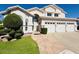 Inviting home with a three-car garage, beautiful lawn, and a walkway leading to the front door at 25015 N 50Th Ave, Phoenix, AZ 85083