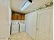 Functional laundry room with washer, dryer, storage cabinets and tile floor provides efficient space at 25015 N 50Th Ave, Phoenix, AZ 85083