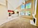 Open-concept living space with vaulted ceiling, large windows, fireplace, and adjacent kitchen at 25015 N 50Th Ave, Phoenix, AZ 85083
