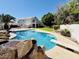 Sparkling backyard pool with rock waterfall, diving board, and lush landscaping at 25015 N 50Th Ave, Phoenix, AZ 85083