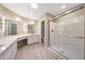 Bathroom featuring modern vanities with sinks, makeup lights, and a glass-enclosed shower at 26649 S Howard Dr, Sun Lakes, AZ 85248