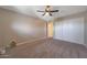 Spacious carpeted bedroom featuring a ceiling fan, closet, and neutral wall color at 26649 S Howard Dr, Sun Lakes, AZ 85248