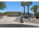 Charming single-story home featuring a two-car garage, palm trees, and a manicured front yard at 26649 S Howard Dr, Sun Lakes, AZ 85248