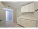 Functional laundry area with white cabinets, counter space, and convenient access to the rest of the home at 26649 S Howard Dr, Sun Lakes, AZ 85248
