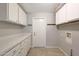 Well-lit laundry room with white cabinets and counter space, offering functionality and storage at 26649 S Howard Dr, Sun Lakes, AZ 85248