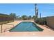 Desert backyard with a sparkling pool, a jacuzzi, lush greenery, and palm trees at 26649 S Howard Dr, Sun Lakes, AZ 85248