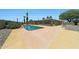 Private backyard pool area featuring a covered patio, palm trees, and desert landscaping at 26649 S Howard Dr, Sun Lakes, AZ 85248