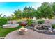Well-manicured backyard featuring a fire pit, spa, water feature, and landscaped garden area at 28878 N 127Th Ln, Peoria, AZ 85383