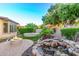 Lush backyard with a fire pit, water feature, and landscaped garden area for relaxation at 28878 N 127Th Ln, Peoria, AZ 85383