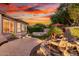 Backyard featuring a modern fire pit, waterfall feature, and spa under a vibrant sky at 28878 N 127Th Ln, Peoria, AZ 85383