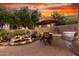 Outdoor dining area with BBQ and outdoor kitchen area with lush landscaping at 28878 N 127Th Ln, Peoria, AZ 85383