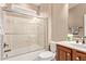 Cozy bathroom with a shower-tub combo with sliding glass doors, a toilet, and a sink at 28878 N 127Th Ln, Peoria, AZ 85383