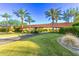 Charming neighborhood entrance with palm trees and lush landscaping over a bridge at 28878 N 127Th Ln, Peoria, AZ 85383
