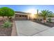 Charming home showcasing a spacious driveway, desert landscaping and attached two-car garage at 28878 N 127Th Ln, Peoria, AZ 85383