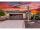 Beautiful home with a two-car garage, desert landscaping, and a dramatic sunset sky at 28878 N 127Th Ln, Peoria, AZ 85383