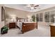 Inviting main bedroom with a ceiling fan, plush carpet, and a large window for natural light at 28878 N 127Th Ln, Peoria, AZ 85383