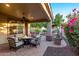 Comfortable outdoor patio with a fire pit, cushioned seating, and lush green landscaping at 28878 N 127Th Ln, Peoria, AZ 85383