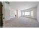 Spacious living room with neutral carpet, bay window, and bright white walls at 5130 W Molly Ln, Phoenix, AZ 85083