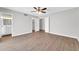 Neutral bedroom boasts wood-look floors, ceiling fan, and access to a private bathroom and walk-in closet at 5237 W Mountain View Rd, Glendale, AZ 85302