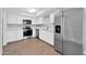 Modern kitchen boasting stainless steel appliances, sleek white cabinetry, and wood-look flooring at 5237 W Mountain View Rd, Glendale, AZ 85302