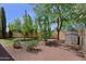 Backyard with well-maintained landscaping features mature trees, shrubs and a storage shed at 5902 E Juniper Ave, Scottsdale, AZ 85254
