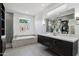 Elegant bathroom with double vanity, soaking tub, and tiled shower with glass door at 615 E Winter Dr, Phoenix, AZ 85020
