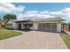 Charming home with a brick driveway, landscaped yard, and a unique glass garage door at 615 E Winter Dr, Phoenix, AZ 85020
