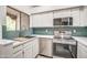 Bright kitchen with stainless appliances, white cabinets, and a sink below a window at 7300 N Dreamy Draw Dr # 202, Phoenix, AZ 85020