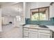 Bright kitchen featuring stainless appliances, white cabinets, and bar area with window at 7300 N Dreamy Draw Dr # 202, Phoenix, AZ 85020