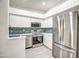 This kitchen features stainless steel appliances, sleek white cabinets, and an eye-catching backsplash at 7300 N Dreamy Draw Dr # 202, Phoenix, AZ 85020