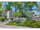 Inviting neighborhood entrance with lush landscaping and mature trees provides a welcoming community vibe at 7300 N Dreamy Draw Dr # 202, Phoenix, AZ 85020
