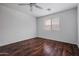 Bedroom with wood floors, ceiling fan, and a window providing natural light at 817 E Lamonte St, San Tan Valley, AZ 85140