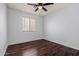 Neutral bedroom with wood floors, ceiling fan, and a window providing natural light at 817 E Lamonte St, San Tan Valley, AZ 85140
