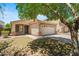 Attractive home featuring a two-car garage, xeriscaping, and a lush tree shading the driveway at 817 E Lamonte St, San Tan Valley, AZ 85140