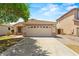 Inviting single-story home with a two-car garage, set against a blue sky and mature tree at 817 E Lamonte St, San Tan Valley, AZ 85140