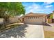 Charming single-story home with a two-car garage, featuring a long driveway and desert landscaping at 817 E Lamonte St, San Tan Valley, AZ 85140