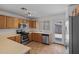 Well-lit kitchen features wood cabinetry, stainless steel appliances, and a convenient breakfast bar at 817 E Lamonte St, San Tan Valley, AZ 85140