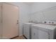 Laundry room showing washer and dryer, tile floor, and door leading outside at 817 E Lamonte St, San Tan Valley, AZ 85140