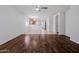 Bright living room showcasing rich hardwood floors, leading to a modern kitchen with bar seating at 817 E Lamonte St, San Tan Valley, AZ 85140